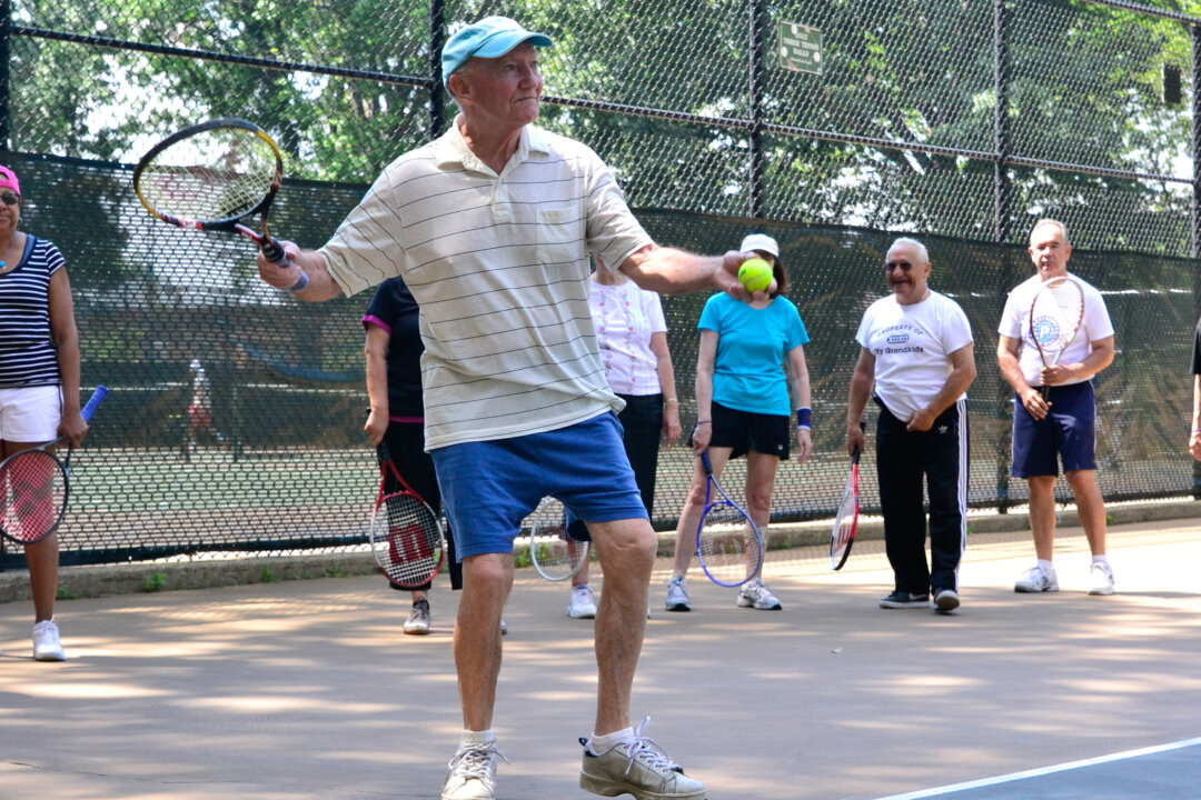 A senior practices his serve during a free tennis course offered by the Parks Foundation. (Justina Wong/Parks Foundation)