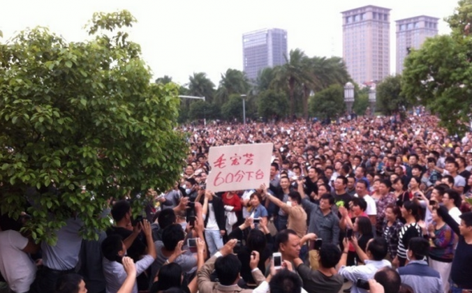 In eastern China's Zhejiang Province tens of thousands of protesters gather in front of the Yuyao City government building on Oct. 15, 2013. A banner held by protesters says “60 Point Mao Hongfang, Step Down." (Weibo.com)