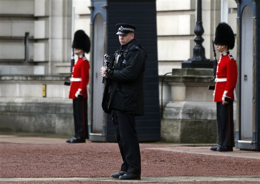 A British police officer guards the grounds of Buckingham Palace in central London, Monday, Oct. 14, 2013, after British police arrested a man, David Belmar, with a knife after he tried to dart through a gate at Buckingham Palace in London on Monday. The palace said Queen Elizabeth II was not in residence. Breaches of royal security are rare, but just a month ago police arrested two men over a suspected break-in at the palace. (AP Photo/Lefteris Pitarakis)