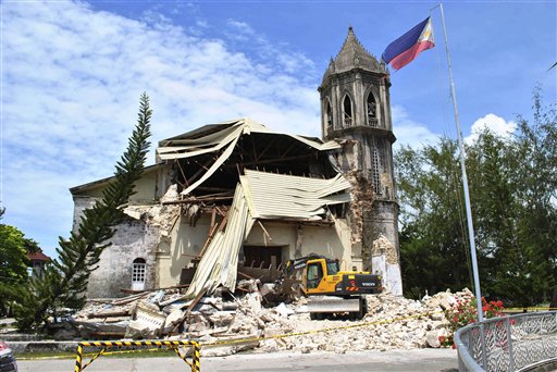 A crane shifts through the rubble of the damaged Our Lady of Assumption Parish church following a 7.2-magnitude earthquake, at Dauis in Bohol, central Philippines, Tuesday Oct. 15, 2013. The tremor collapsed buildings, cracked roads and toppled the bell tower of the Philippines' oldest church Tuesday morning, causing multiple deaths across the central region and sending terrified residents into deadly stampedes. (AP Photo)
