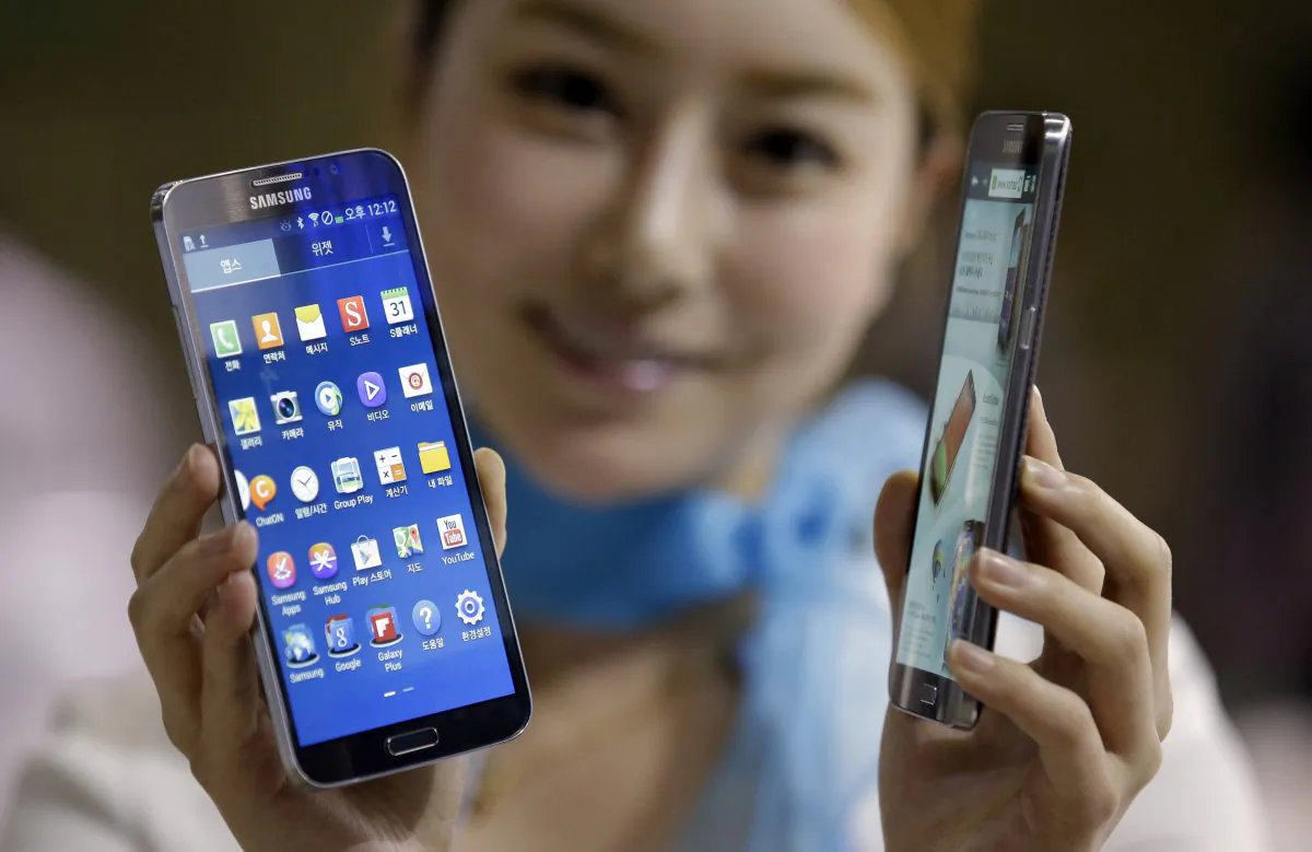 FILE - In this Oct. 10, 2013 file photo, a model poses with Samsung Electronics' smartphones the Galaxy Round at Korea Electronics Show in Goyang, west of Seoul, South Korea. (AP Photo/Lee Jin-man, File)