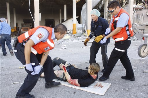 Rescue workers help an injured man after an explosion at a candy factory in Ciudad Juarez, Mexico, Thursday, Oct, 24, 2013. The explosion happened at the Dulces Blueberry factory and caused the floor to collapse, said factory worker Ismael Bouchet. (AP Photo/Raymundo Ruiz)