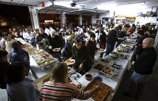 People enjoy a pot luck dinner in Sea Bright fire department in Sea Bright, N.J., Oct. 29, 2013, as residents marked the one-year anniversary of Superstorm Sandy. (AP Photo/Mel Evans)