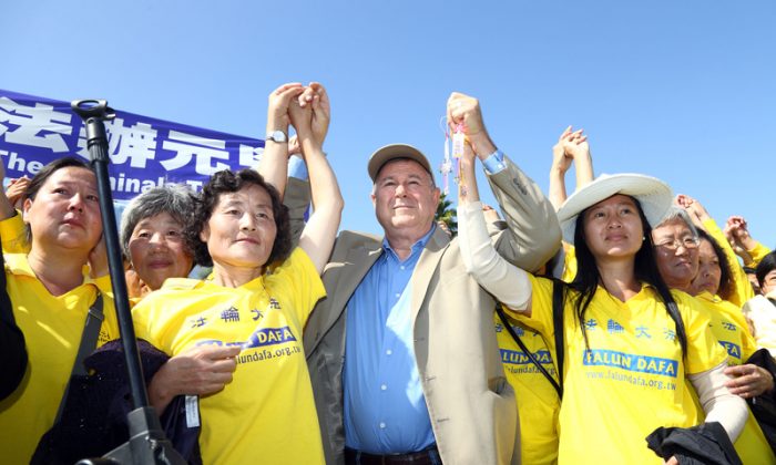 Congressman Dana Rohrabacher holds hands with Falun Gong practitioners during a rally calling for an end to the persecution to Falun Gong in China, at Long Beach in Los Angeles on Oct. 20. (Song Xianglong/Epoch Times)