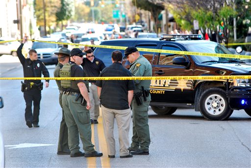 Authorities gather in front of the Federal Building in Wheeling, W.Va, on Wednesday, Oct. 9, 2013. West Virginia State Police say a man who fired shots at a federal courthouse in Wheeling has died from police fire. State police spokesman Sgt. Michael Baylous confirmed that the man died Wednesday. The U.S. Marshals Services says officers fired at the man after he shot up to two dozen rounds at the courthouse. (AP Photo/Wheeling News Register & The Intelligencer, Scott McCloskey)