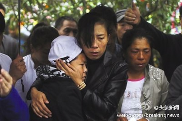 Vendor Xia Junfeng's wife (c) and son attend Xia's funeral at Memorial Forest Cemetery at suburb of Shenyang City on Oct. 1. (Weibo.com)