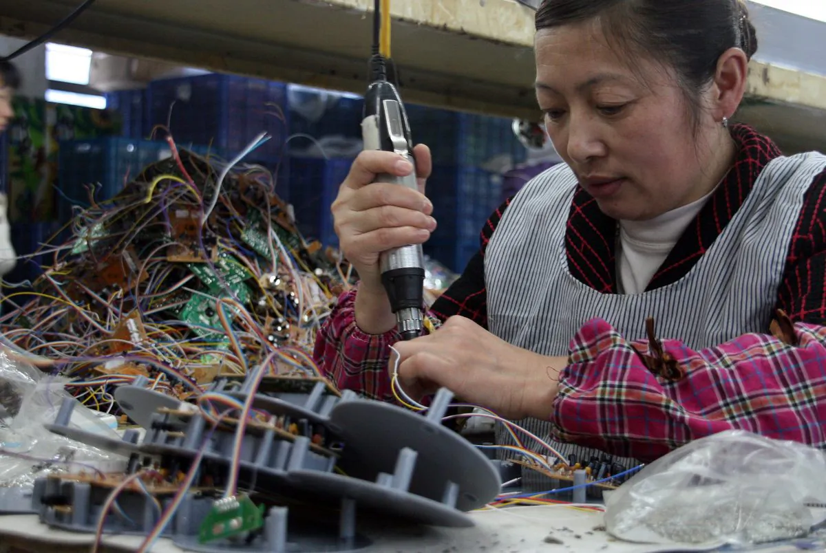 In this file photo a woman is at work in a factory in southeast China's Fujian Province on April 2, 2011. Even the simplest electronic appliances made in China may come with a surprise—a device intended to enable cyber crime. (STR/AFP/Getty Images)