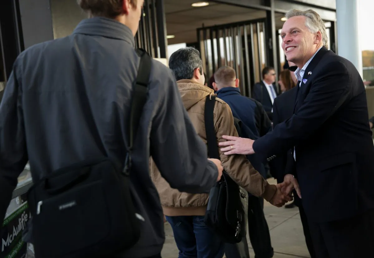 Democratic Virginia gubernatorial candidate Terry McAuliffe (R) greets commuters at Vienna/Fairfax-GMU Metro Station in Fairfax, Va. on Election Day, Nov. 5. He won a narrow victory. (Alex Wong/Getty Images)
