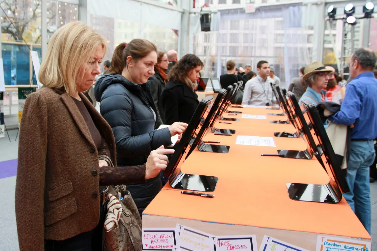 Visitor fill out a five-question survey on tablets at the Transition Tent on Canal Street, New York, Nov. 17, 2013. (Ivan Pentchoukov/Epoch Times)