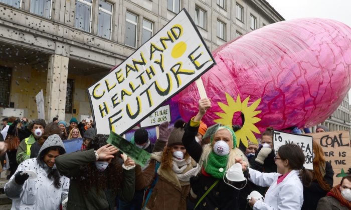 Young environmentalists from international organizations protest in front of the Polish Ministry of Economy in Warsaw, where the COP 19 climate summit is taking place, Nov. 18, 2013. Canada has placed last among wealthy countries in an OECD ranking for environmental protection. (Janek Skarzynski/AFP/Getty Images) 