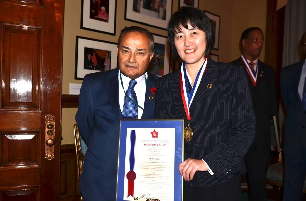 Epoch Times publisher Cindy Gu stands with Thomas Saras, president of the National Ethnic Press and Media Council, on Nov. 9, 2012, upon receiving the organization’s national ethnic press award on behalf of the Chinese edition of the Epoch Times. In response to a recent report, Saras endorses the call for more federal support for ethnic publications. (Tanya Dy/Epoch Times)