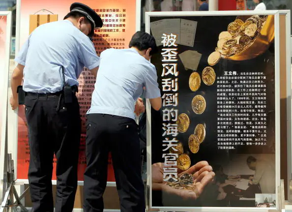 Chinese policemen set up anti-corruption billboards in Central Beijing, June 11, 2007. (Teh Eng Koon/AFP/Getty Images)