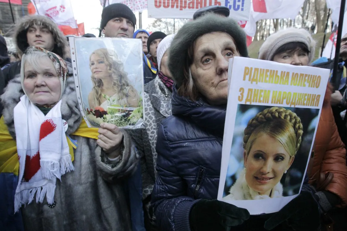 Activists of the Ukrainian Opposition Party hold a posters with a photo of former Ukrainian Prime Minister Yulia Tymoshenko  during a rally in front of the Ukrainian Cabinet of Ministers in Kiev, Ukraine, Wednesday Nov. 27, 2013.  Tymoshenko celebrates her 53rd birthday today. (AP Photo/Sergei Chuzavkov)