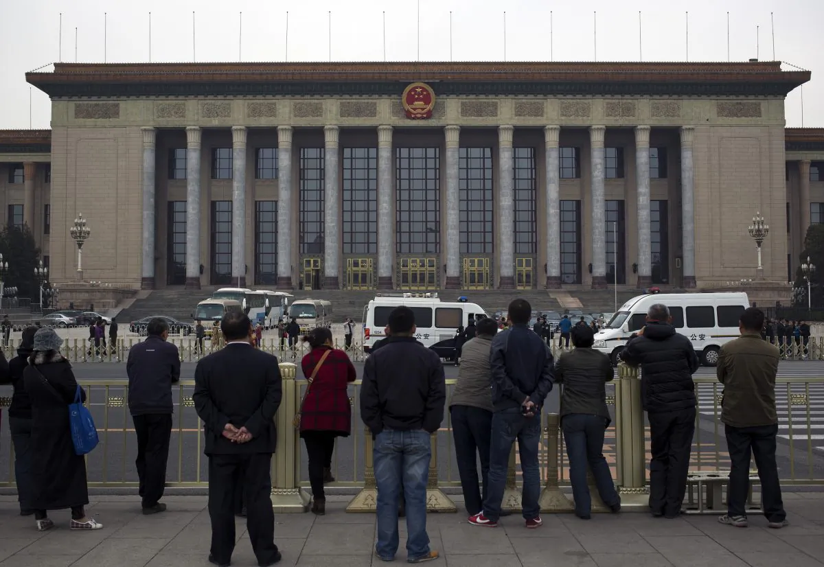 People watch as police officers check visitors in front of the Great Hall of the People during a gathering of the 205-member Central Committee's third annual plenum in Beijing, China Saturday, Nov. 9, 2013. The watchword for the Chinese Communist Party’s Third Plenum of the 18th Central Committee has been “reform.” (AP Photo/Andy Wong)