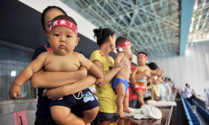 Increasing numbers of wealthy Chinese couples are hiring the services of American surrogate mothers to give birth to their babies to circumvent China's one child policy. In the photo, hundreds of Chinese babies accompanied by their parents prepare to take part in a baby swimming contest. (STR/Getty Images) 