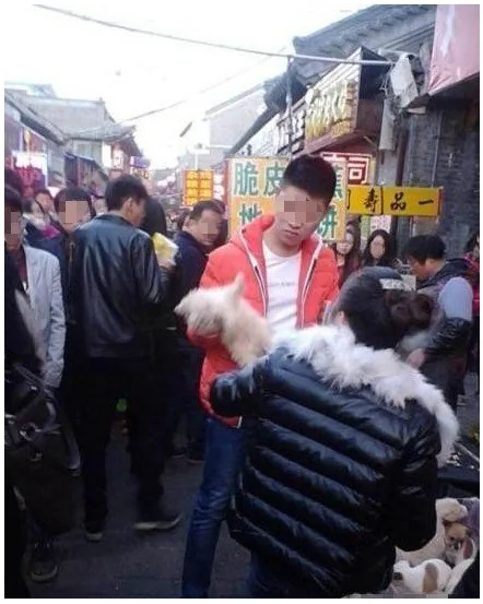 Screenshot shows a Chinese man alleged to have killed a small dog on sale at a market stall, after it bit him. (Tencent QQ/Screenshot/Epoch Times)