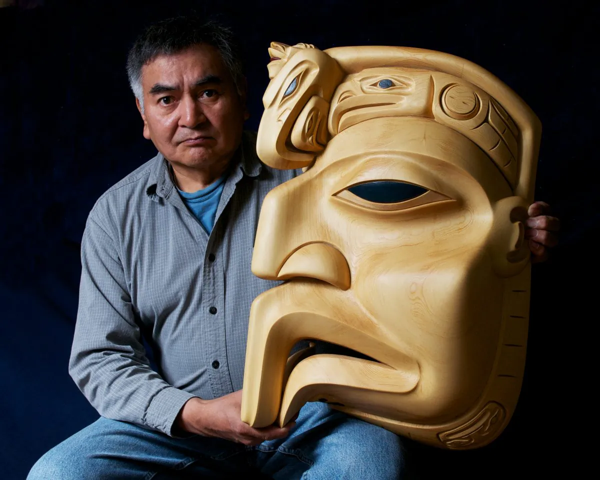 Dempsey Bob poses with his carving "Eagles from the North." (Graeme Joseph)