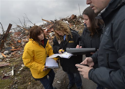 Officials from FEMA and IEMA make an assessment of the tornado damage to homes in Washington, Ill., on Thursday, Nov. 21, 2013. As federal storm damage assessors started working across Illinois on Thursday, state officials revised the number of homes destroyed or damaged by the weekend's tornadoes upward to at least 1,500. (AP Photo/Journal Star, Ron Johnson)