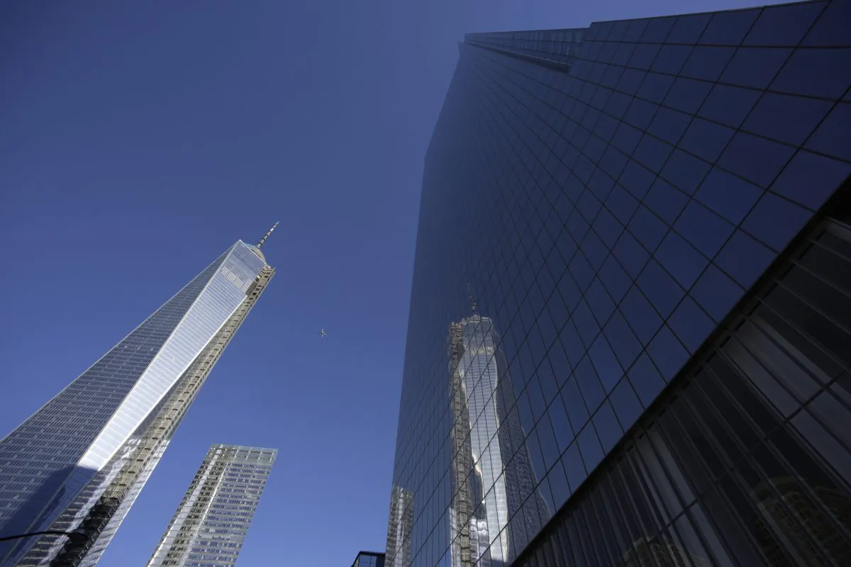 1 World Trade Center (L) is reflected in the glass facade of its neighbor, 4 World Trade Center, in New York, Nov. 13, 2031. A ribbon-cutting was held to open the 977-foot 4 World Trade Center. (Mark Lennihan/AP)