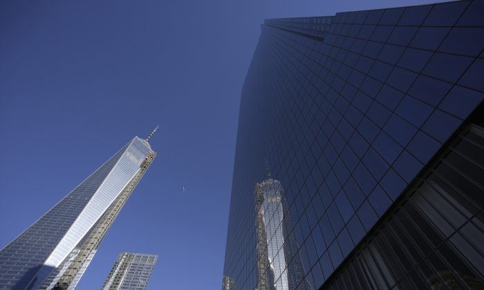 1 World Trade Center (L) is reflected in the glass facade of its neighbor, 4 World Trade Center, in New York, Nov. 13, 2031. A ribbon-cutting was held to open the 977-foot 4 World Trade Center. (Mark Lennihan/AP)
