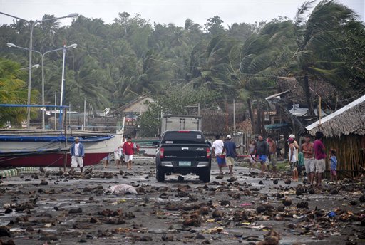 Debris litters the road by the coastal village in Legazpi city following a storm surge brought about by powerful Typhoon Haiyan in Albay province Friday, Nov. 8, 2013, about 520 kilometers ( 325 miles) south of Manila, Philippines. The strongest typhoon this year slammed into the central Philippines on Friday, setting off landslides and knocking out power and communication lines in several provinces. (AP Photo/Nelson Salting)