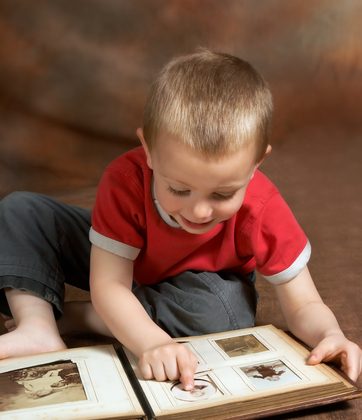 A file photo of a boy looking through an old photo album. A boy called Sam in case studies made some startling statements while looking through old family photos, cited as evidence along with numerous other cases of reincarnation. (Shutterstock*)