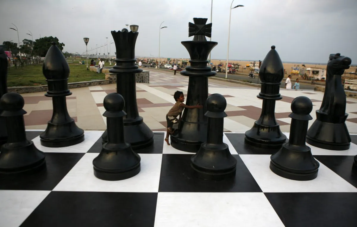 An Indian child plays around a huge chessboard model erected to mark the FIDE World Chess Championship at the Marina beach on the Bay of Bengal coast in Chennai, India, on Nov. 7, 2013. (Arun Sankar K/AP Photo)