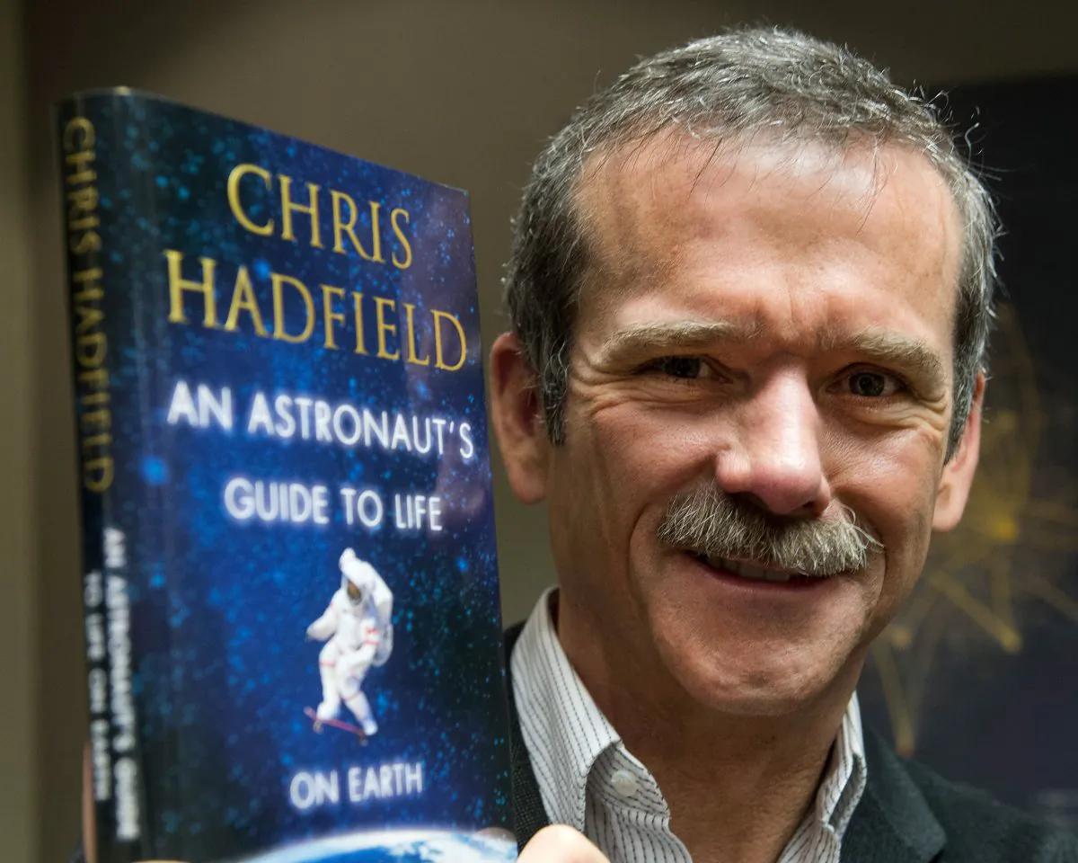 Chris Hadfield holds a copy of his new book while on a media tour Wednesday, November 27, 2013 in Montreal. A flash of light and a loud boom heard in the Montreal and Ottawa areas on Tuesday night was just the universe doing its thing, the retired astronaut says. (The Canadian Press/Ryan Remiorz)