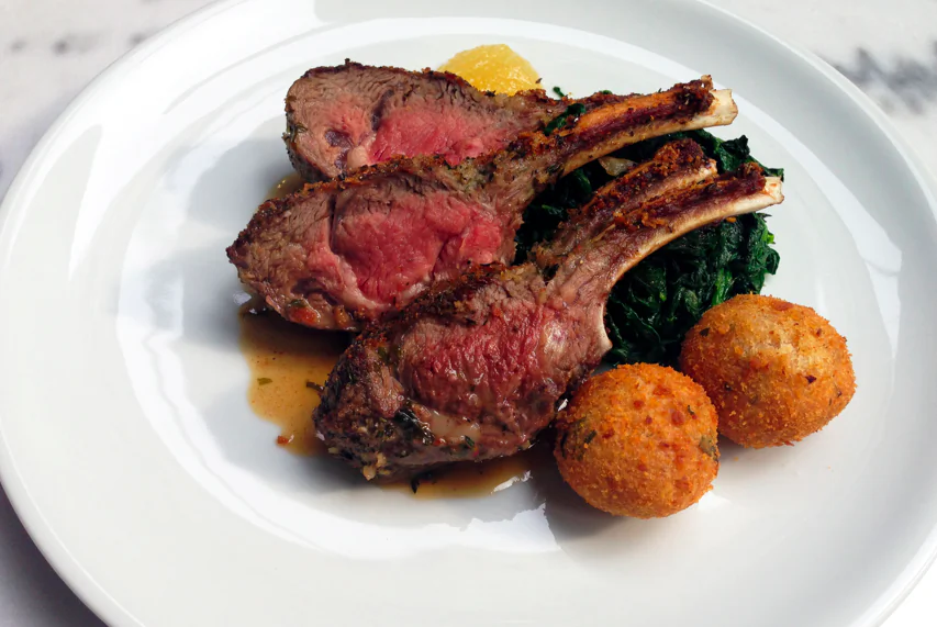 Colorado Rack of Lamb in herb crust with potato croquette and sautéed spinach, served with fruit mustard sauce. (Courtesy of Il Gattopardo)
