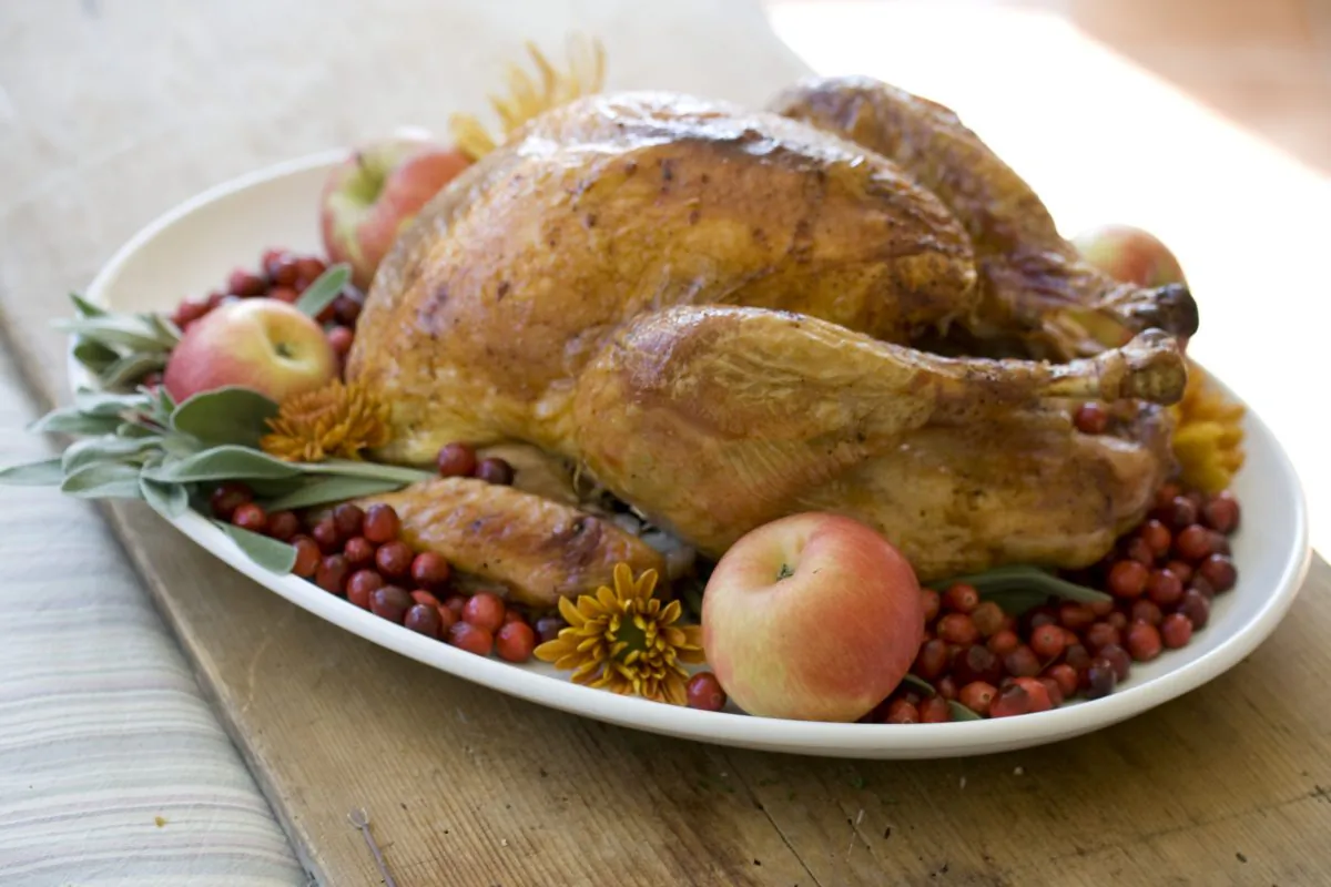 This Oct. 14, 2013 photo shows grilled turkey with maple Southern Comfort glaze prepared with an orange turkey brine. Using an indirect heat outdoor grill can take less time than traditional oven roasting. (AP Photo/Matthew Mead)