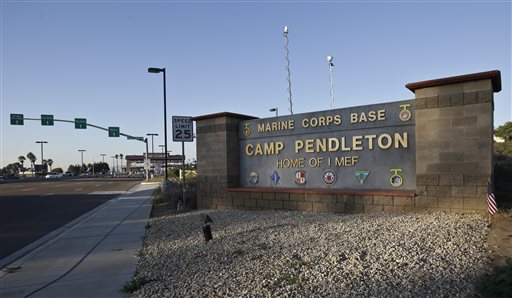 Vehicles file through the main gate of Camp Pendleton Marine Base on Wednesday, Nov. 13, 2013, at Camp Pendleton, Calif. Four Marines were reported killed today in an accident while clearing an unexploded ordnance. (AP Photo/Lenny Ignelzi)