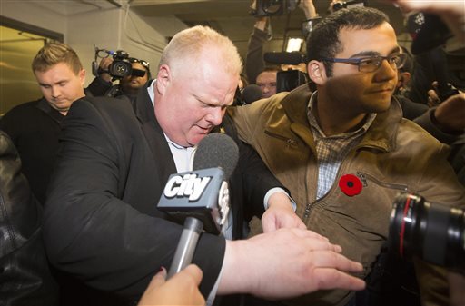 Toronto Mayor Rob Ford walks to his car through a pack of reporters and camera operators in the parking garage after talking on his weekly radio show in Toronto, Sunday, Nov. 3, 2013. (AP Photo/The Canadian Press, Mark Blinch)