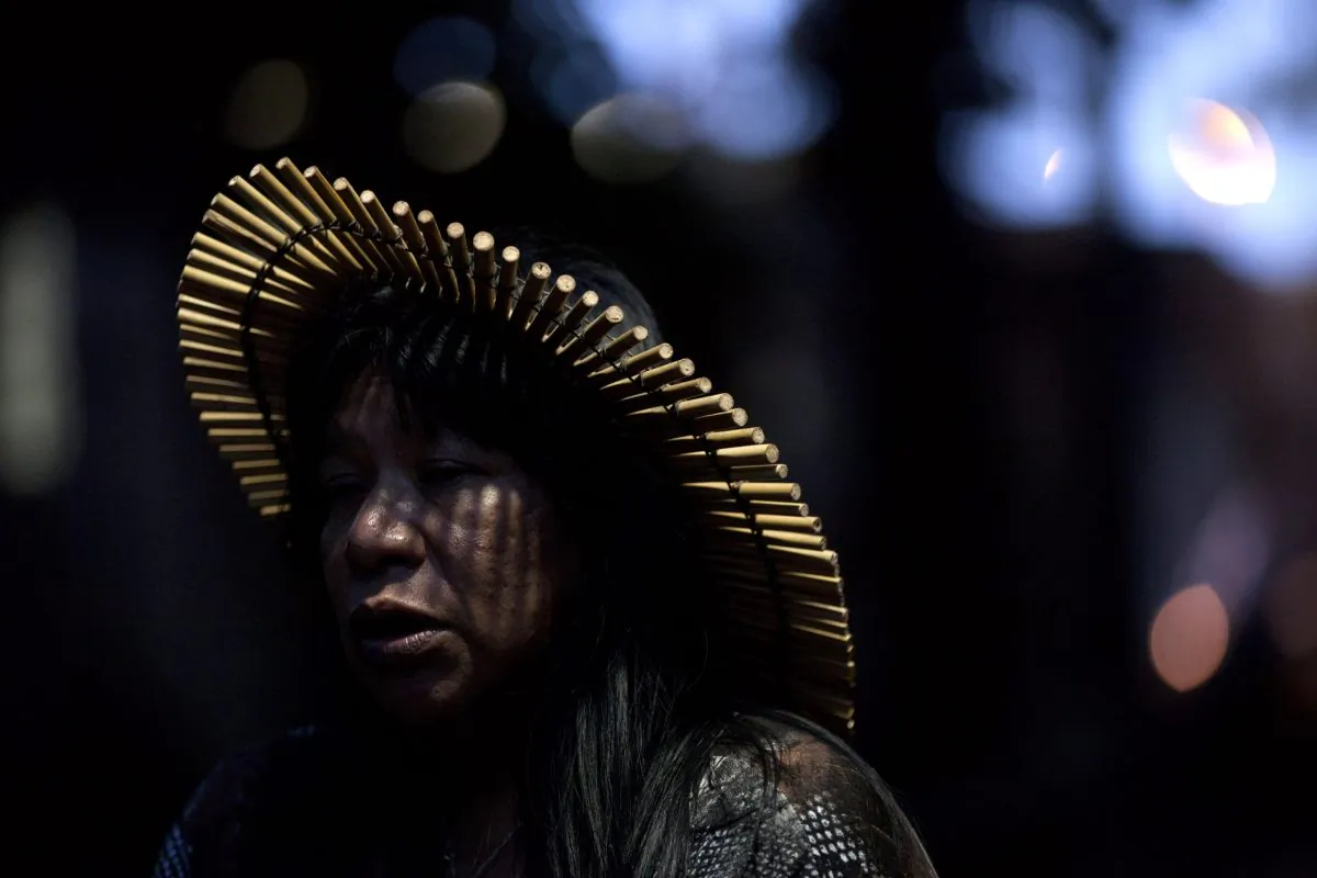 A woman participates in a protest on June 21, 2012, near the Maracana stadium in Rio de Janeiro, Brazil, where local residents are due to be relocated to make way for World Cup construction. Many decry the games hosted by Brazil as damaging to the most disadvantaged residents. (AP Photo/Felipe Dana)