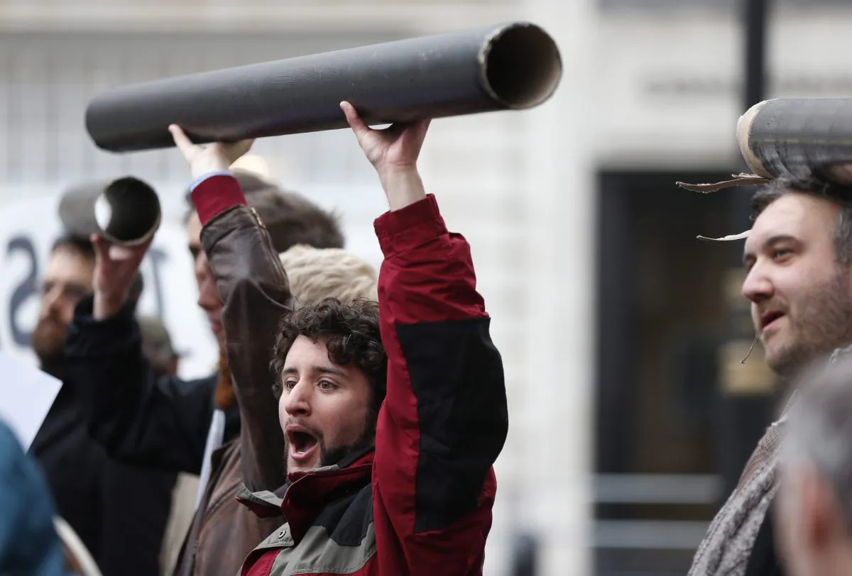 Protesters hold mock-ups of pipes during a demonstration near the G8 foreign ministers’ meeting in central London, Thursday, April 11, 2013. (AP Photo/Lefteris Pitarakis)