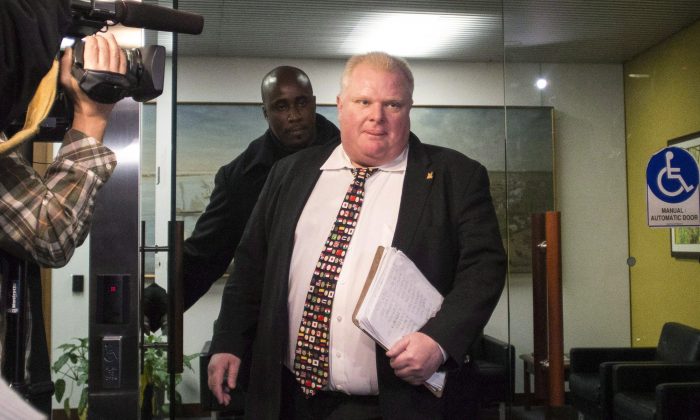 Mayor Rob Ford arrives at city hall in Toronto on Nov. 19, 2013. Newly released documents say police overheard alleged gang members on wiretaps talking about delivering drugs to Ford and having pictures of him using drugs, suggesting the images could be used for blackmail. (The Canadian Press/Chris Young)
