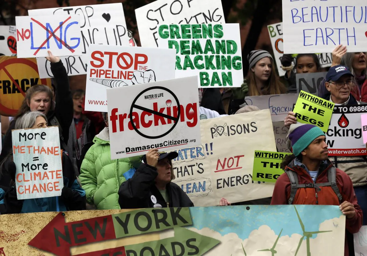 In this Oct. 30, 2013, photo, people hold signs during a rally against hydraulic fracturing for natural gas, or fracking, in Albany, N.Y. (AP Photo/Mike Groll)