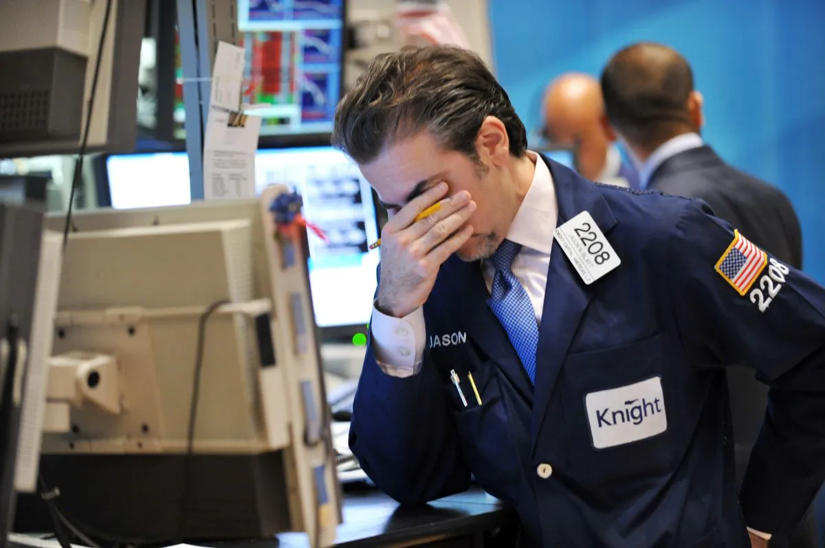 A trader for Knight Capital reacts to a down market on the floor of the New York Stock Exchange, Aug. 8, 2011. The company's algorithmic trading desk suffered heavy losses in 2012, illustrating the broader risk high-frequency trading poses to the markets.
(Stan Honda/AFP/Getty Images)