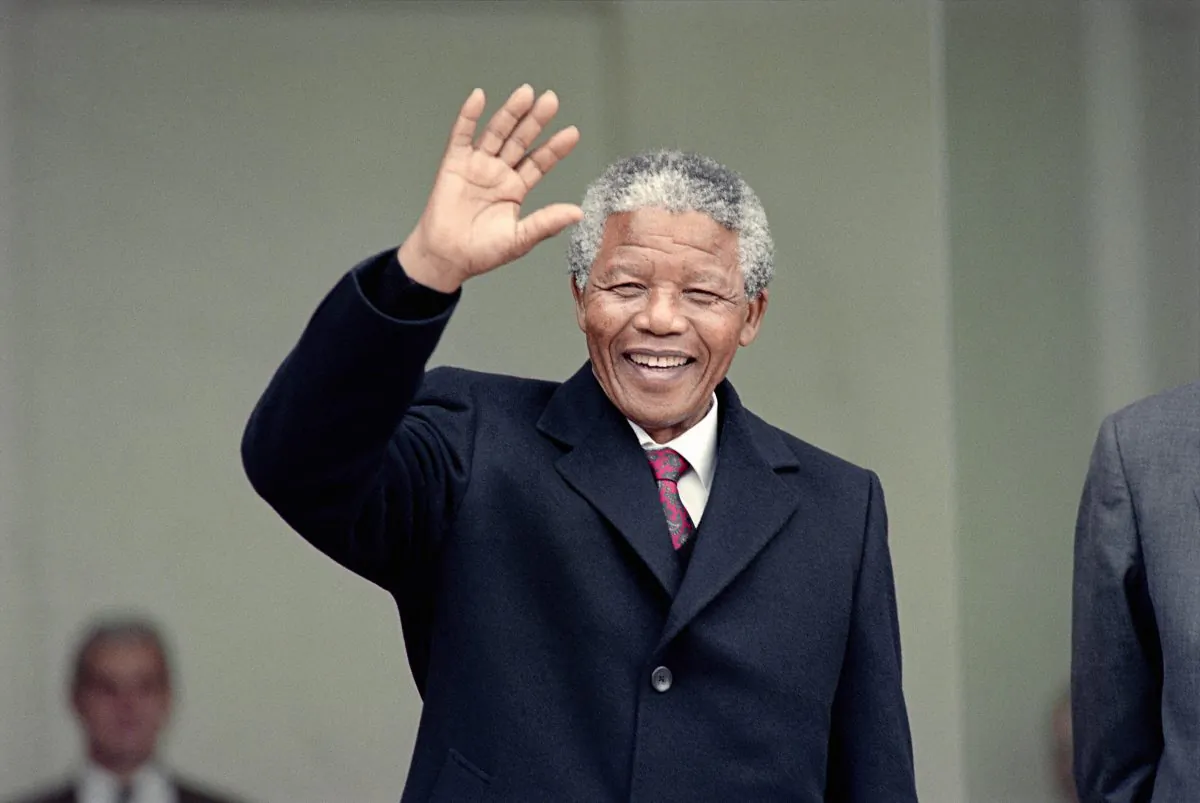Nelson Mandela waves to the press as he arrives at the Elysee Palace, 07 June 1990, in Paris, to have talks with French president Francois Mitterrand. (Michel Clement, Daniel Janin/AFP/Getty Images)