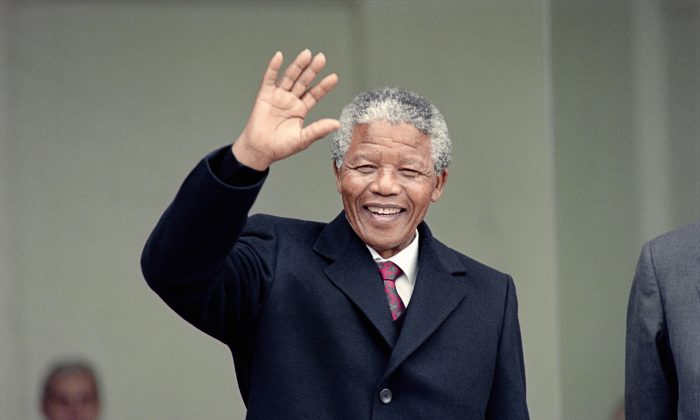 Nelson Mandela waves to the press as he arrives at the Elysee Palace, 07 June 1990, in Paris, to have talks with French president Francois Mitterrand. (Michel Clement, Daniel Janin/AFP/Getty Images)

