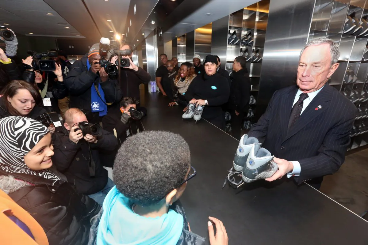 Mayor Michael Bloomberg hands a pair of rental skates to a boy on the opening day of the LeFrak Center Ice Rink in Brooklyn, New York, on Dec. 17, 2013. (Spencer Tucker)