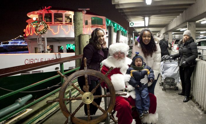 Santa poses with one of the last children in line to a holiday cruise boat at Pier 81 in Manhattan, New York, Dec. 9, 2013. (Samira Bouaou/Epoch Times)