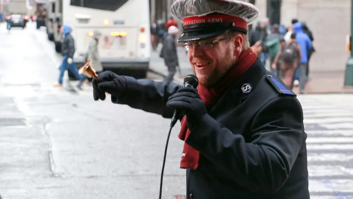 Michael Buzzard rings and sings outside New York Penn Station on Dec. 10, 2013. (Allen Xie)
