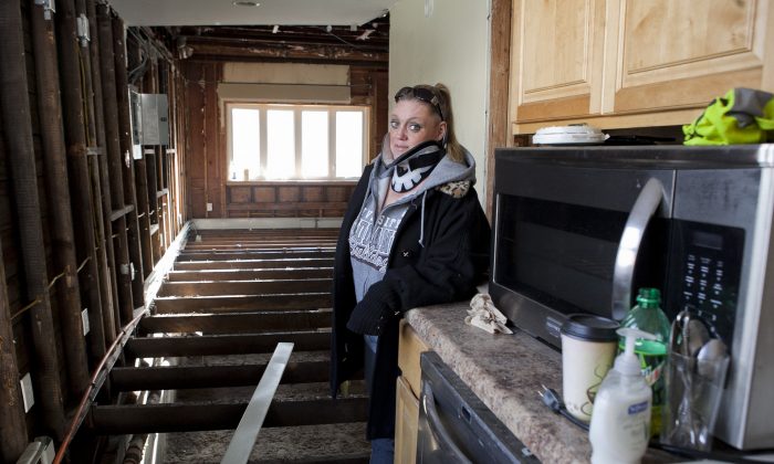Stacey Walsh in her home in Broad Channel, Queens. About seven months after Sandy, she was seriously injured in a car crash that left her in a neck brace. (Samira Bouaou/Epoch Times)