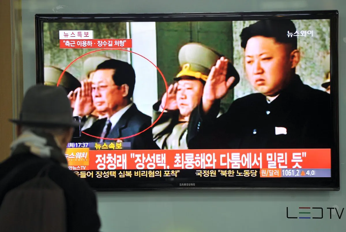 A South Korean man watches TV news about the dismissal of Jang Song-Thaek, North Korean leader Kim Jong-un's uncle, at a railway station in Seoul on Dec. 3, 2013. Jang is circled in red and on the far right is Kim Jong-un, who ordered Jang's execution (Jung Yeon-Je/AFP/Getty Images) 