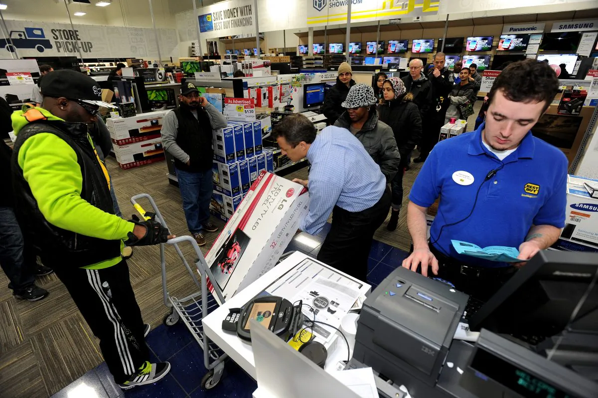 In this Nov. 29, 2013, file photo, Best Buy employee Christopher Gervais, right, rings up a 32-inch LED TV in Dunwoody, Ga. Sales at U.S. stores dropped 3.1 percent to $42.7 billion for the week that ended on Sunday, Dec. 22, 2013, compared with the same week last year, according to ShopperTrak, which tracks data at 40,000 locations. (AP Photo/David Tulis, File)