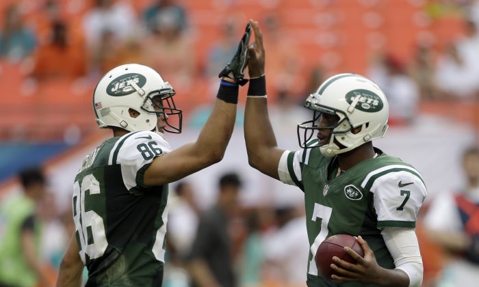 New York Jets quarterback Geno Smith (7) gives a high-five to teammate David Nelson (86) before the last play against the Miami Dolphins in the fourth quarter of a NFL football game in Miami Gardens, Fla., Sunday, Dec. 29, 2013. The Jets won 20-7. (AP Photo/Alan Diaz)
