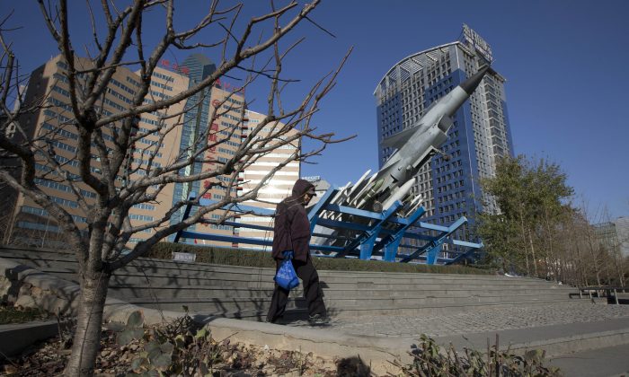 A Chinese woman walks near a replica of a Chinese fighter jet displayed in Beijing on Nov. 27, 2019. (Ng Han Guan/AP Photo) 