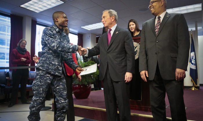 Philip Essienyi, navy petty officer 3rd class from Ghana (L), shakes hands with Mayor Michael Bloomberg after receiving his certificate of citizenship during a naturalization ceremony in New York, Dec. 18, 2013 (Bebeto Matthews/AP)