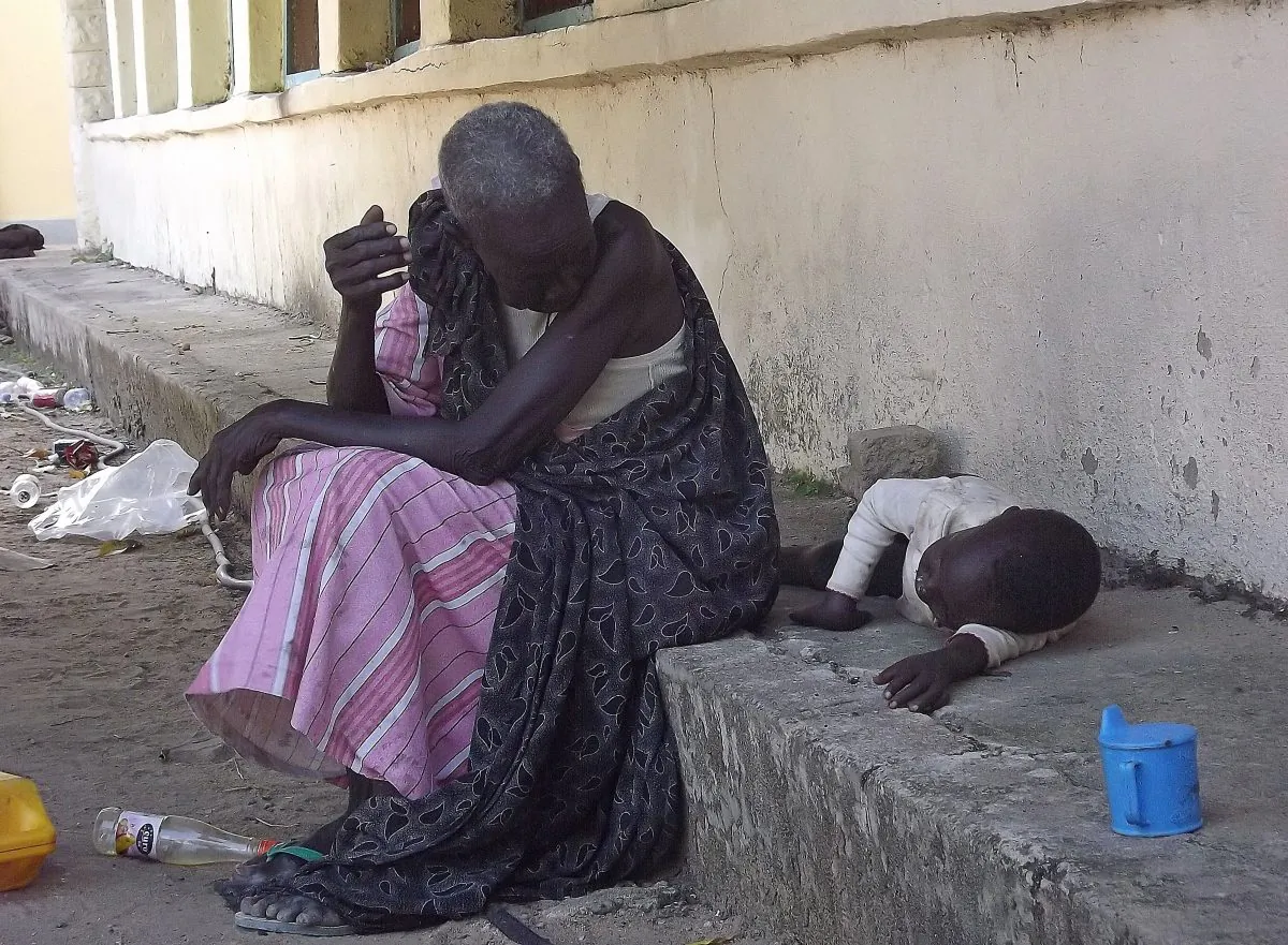 A South Sudanese woman with a child sits on Dec. 25 at the main hospital in Bor which troops loyal to President Salva Kiir re-captured from rebel forces. South Sudan is caught in a political struggle turned ethnic cleansing, with an estimated death-toll in the thousands, and the number of displaced people approaching 100,000. (Samir Bol/AFP/Getty Images)