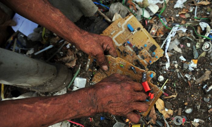 A man collects copper from an electronic circuit to sell for recycling, in a landfill of Managua, Nicaragua, on Jan. 11, 2013. E-waste is among the top environmental issues facing our world in 2014; new products are entering the market aimed at giving us our high-tech devices with less waste. (Hector Retamal/AFP/Getty Images)